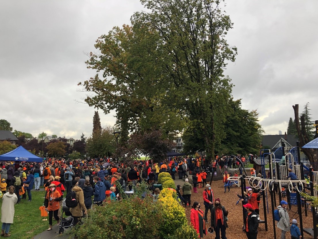 A busy park with many people wearing orange shirts