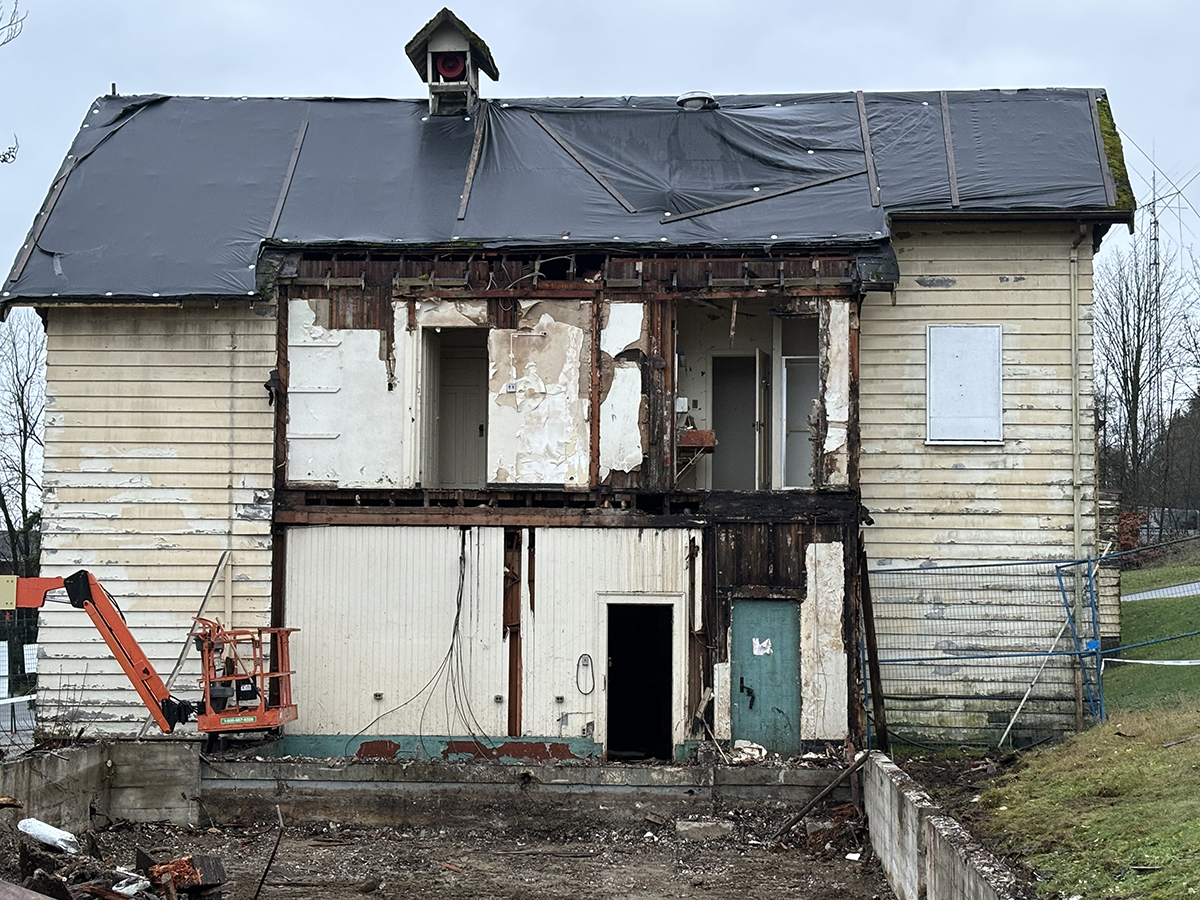 Old worn and tattered looking fire hall in process of being torn down.